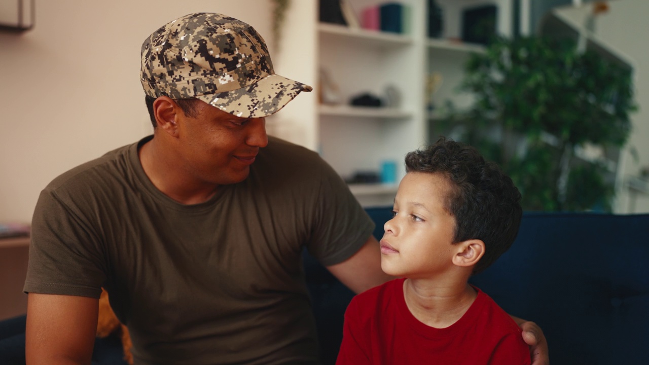 非裔美国军人父亲和小儿子在家里交谈和拥抱视频下载