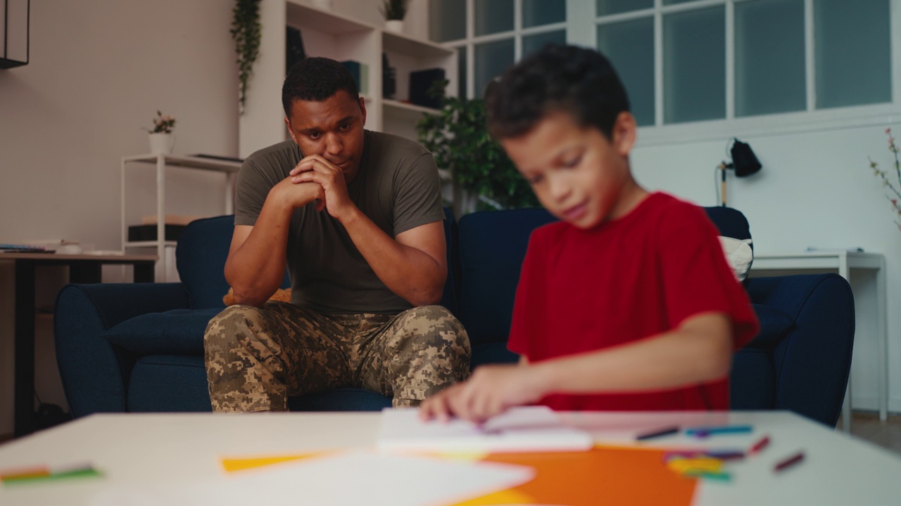 伤心的士兵看着小儿子在家里画画，男人要去打仗了视频下载