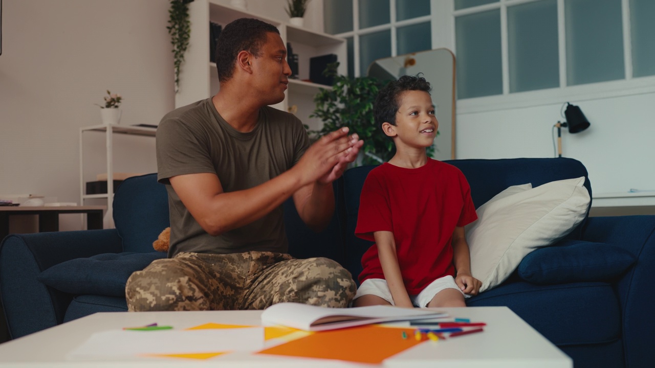 快乐的军人爸爸和小儿子在房间里发射纸飞机，幸福极了视频下载