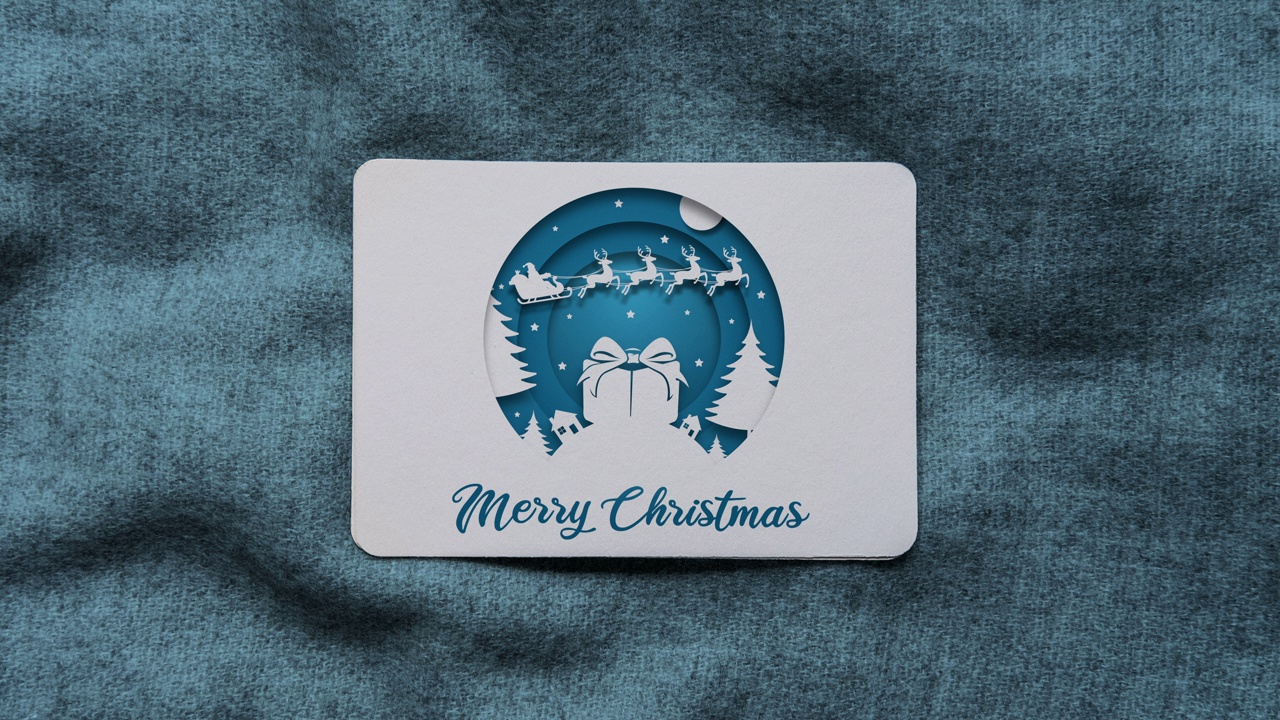 蓝色彩色剪纸风格的圣诞老人和飞行驯鹿动画与圣诞快乐的文字圣诞贺卡视频下载