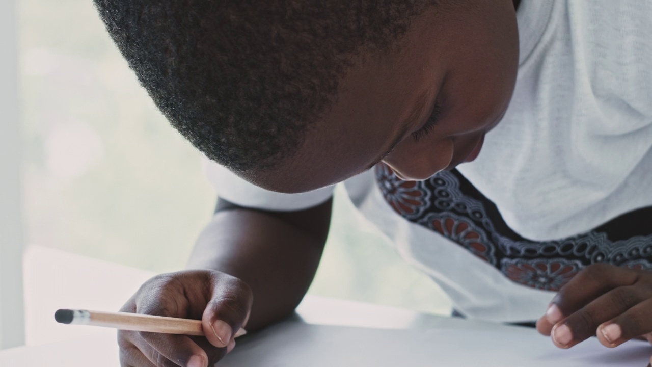 非裔美国男孩用铅笔在桌子上写字视频素材