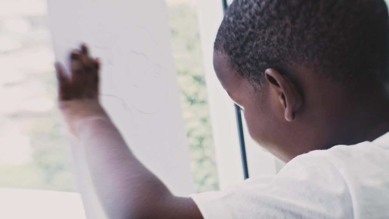 黑人男孩在纸上画画视频素材