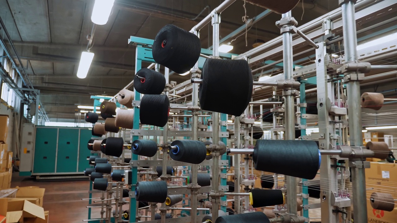 线轴上。纺织工业。纺织工厂。有许多线轴的机架。为进一步生产织物而对纱线进行染色和干燥。自动化的工作流程。纺织生产。视频下载