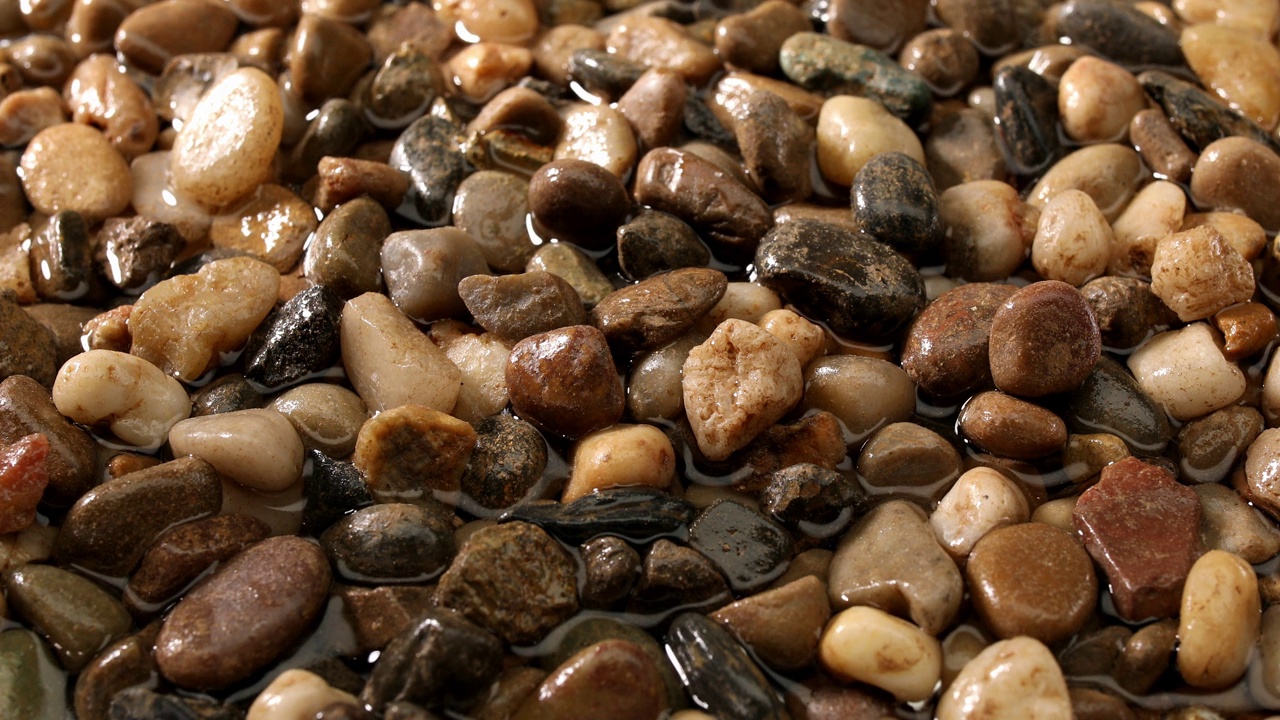 多色的小湿鹅卵石从海边留下的水。视频下载