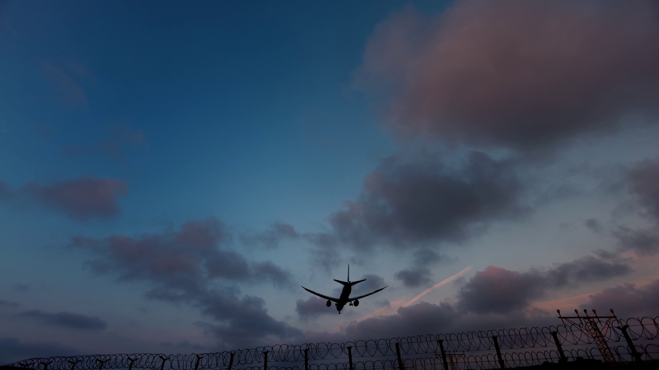 黄昏时分，一架客机从头顶飞过，降落在机场视频下载