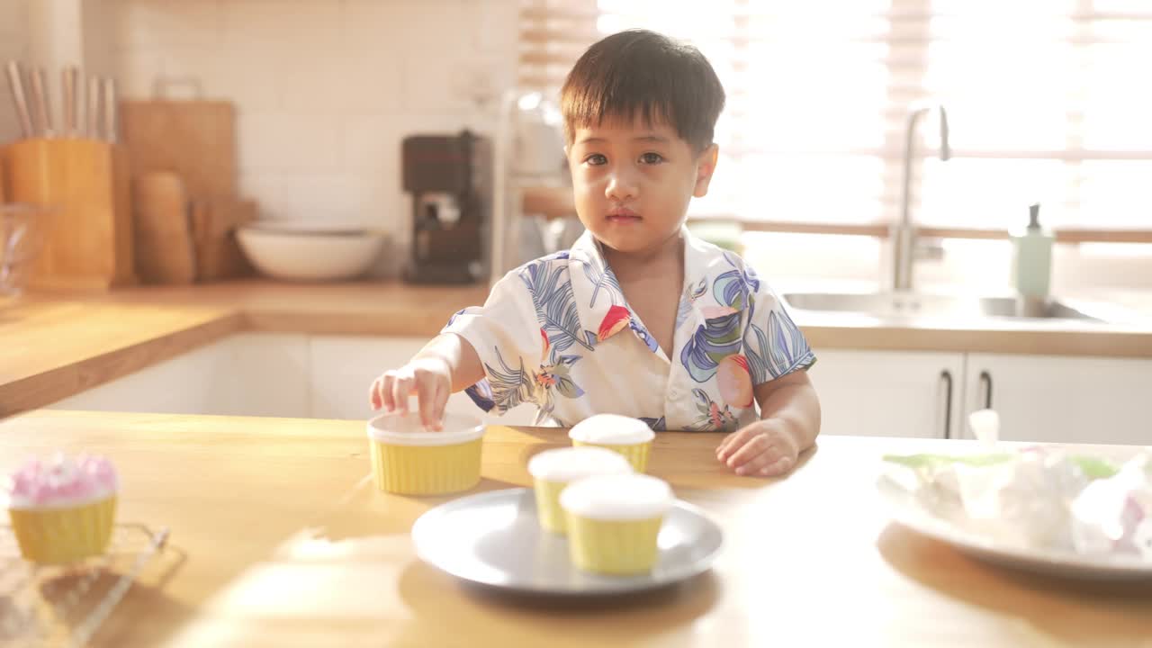 家庭自制的幸福:亚洲孩子在他们的厨房里烹饪甜蜜的回忆。视频下载
