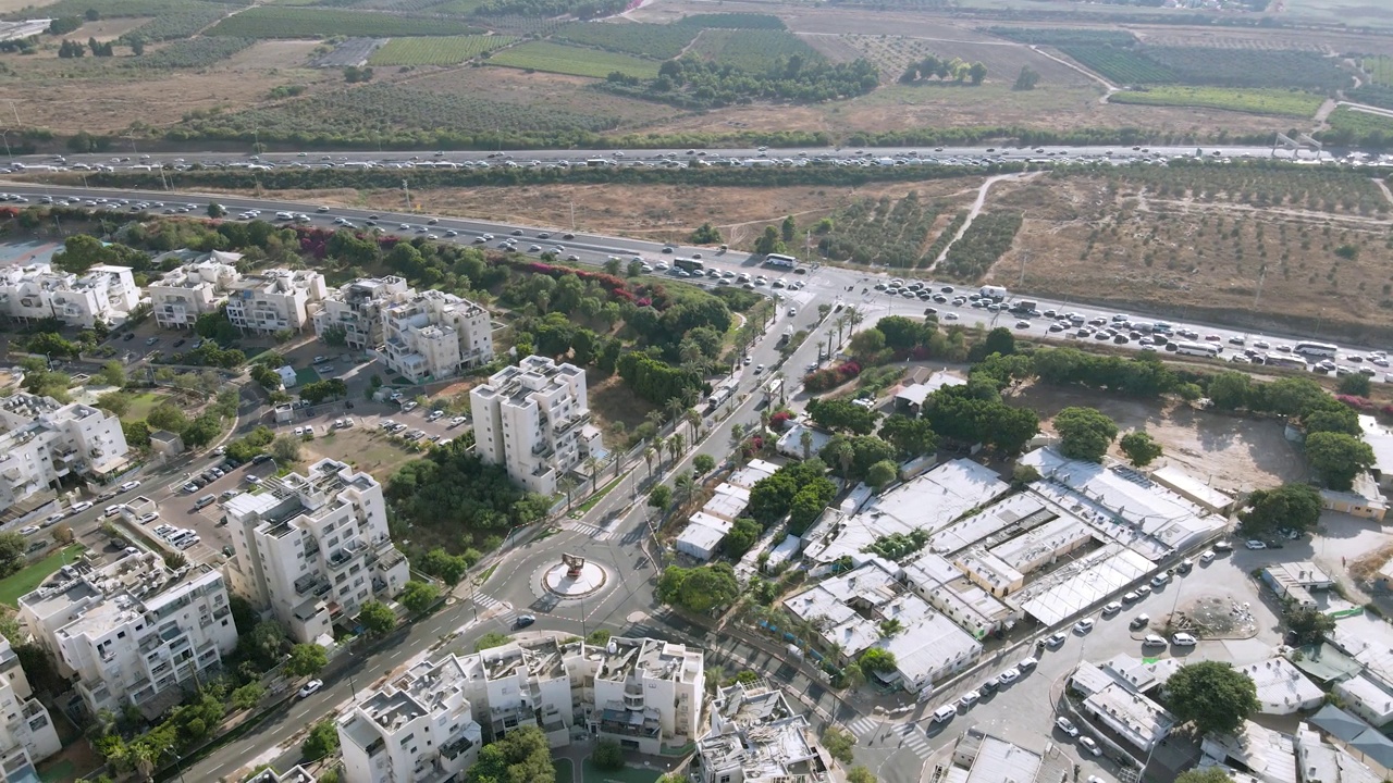 以色列中部城市一个繁忙的道路交叉口和交通枢纽的鸟瞰图。
背景是穿越以色列的高速公路。
田野和果园环绕着城市。视频下载