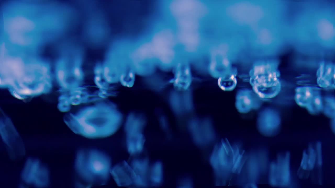 10/13/2022特写水在透明玻璃杯中冒泡或沸腾。在黑色的背景上视频下载