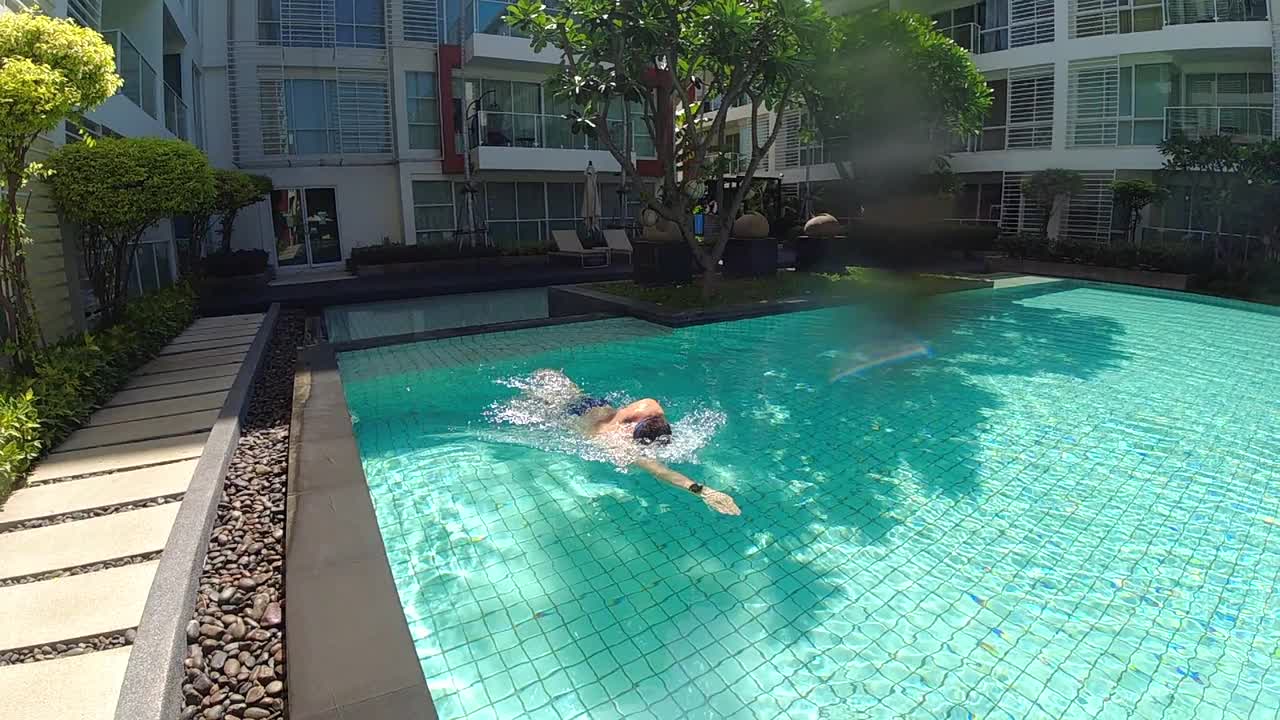 一个人正在度假时的游泳池里游泳。慢动作视频视频下载