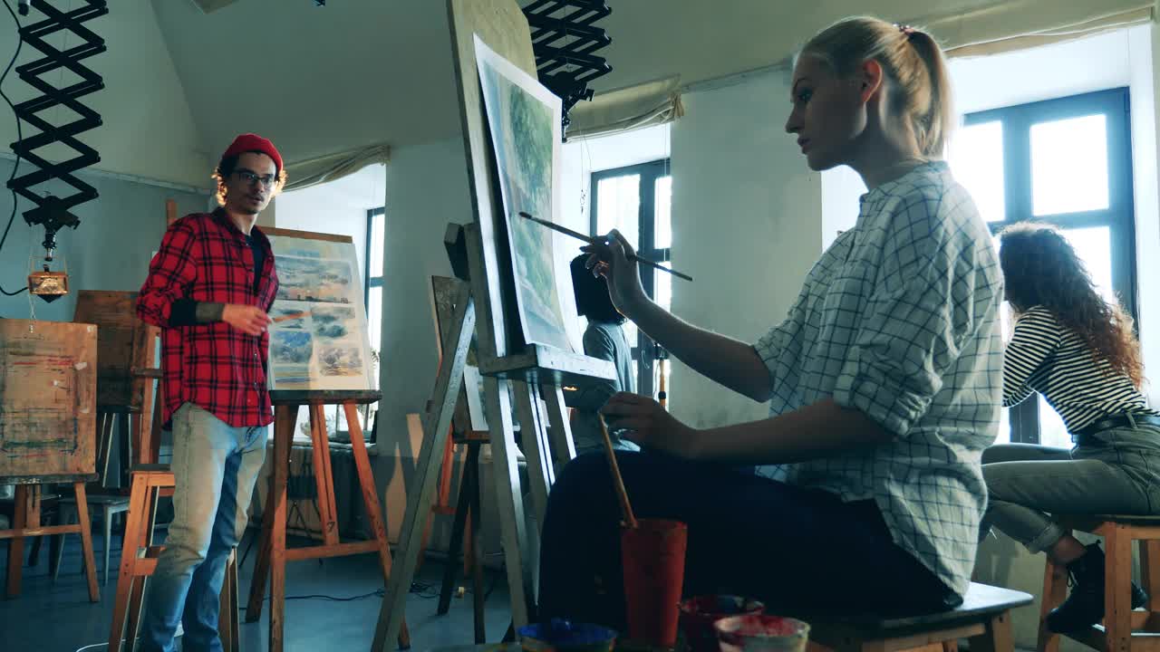 一群妇女正在和一位男画家一起上美术课。艺术教育理念。视频下载