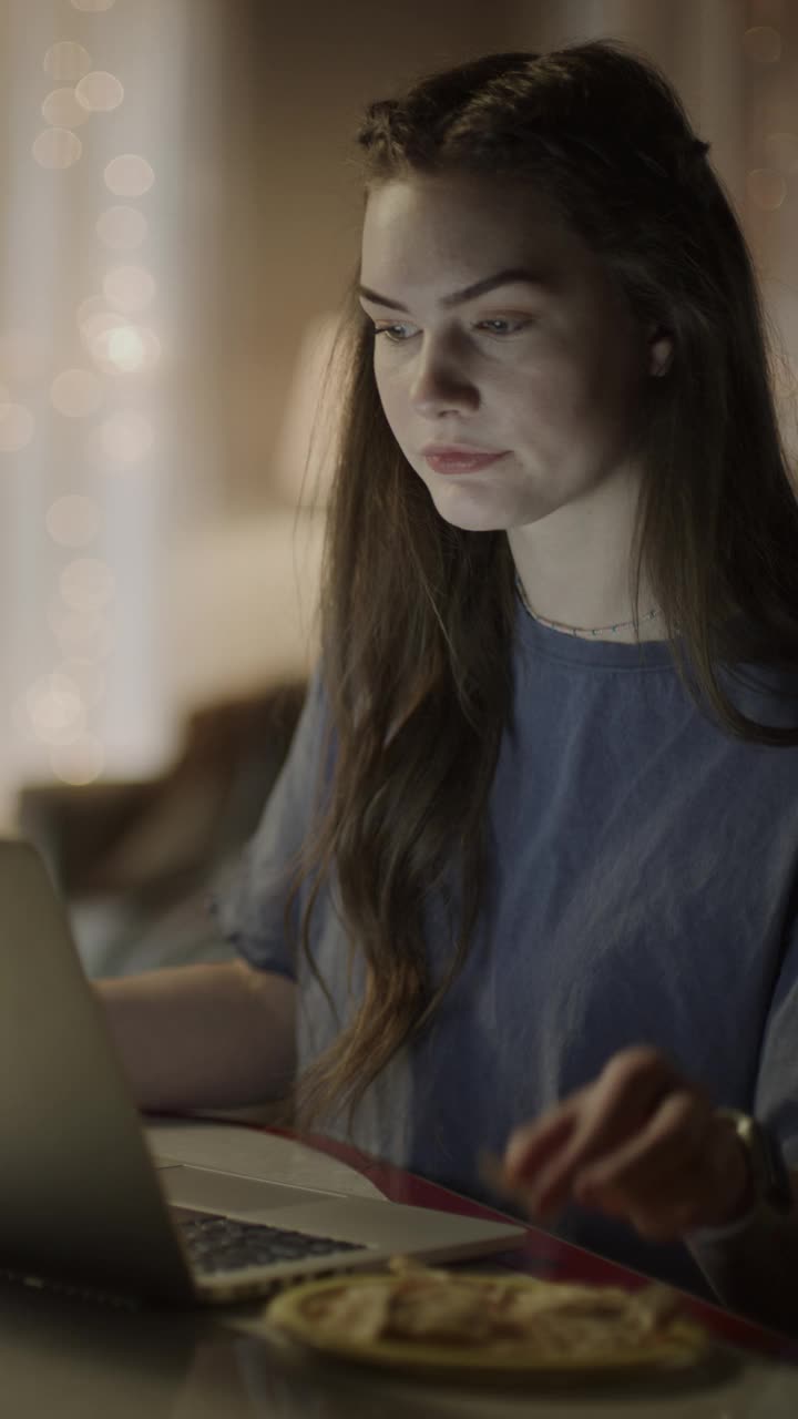 女孩在网上学习，在笔记本电脑上做笔记在晚上-垂直视频/雪松山，犹他州，美国视频下载
