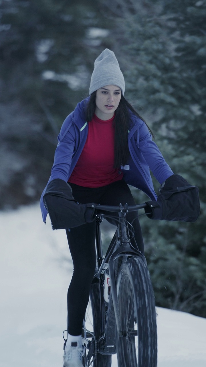 慢动作接近的女孩骑胖自行车在雪地里垂直视频/ Tibble Fork，犹他州，美国视频下载