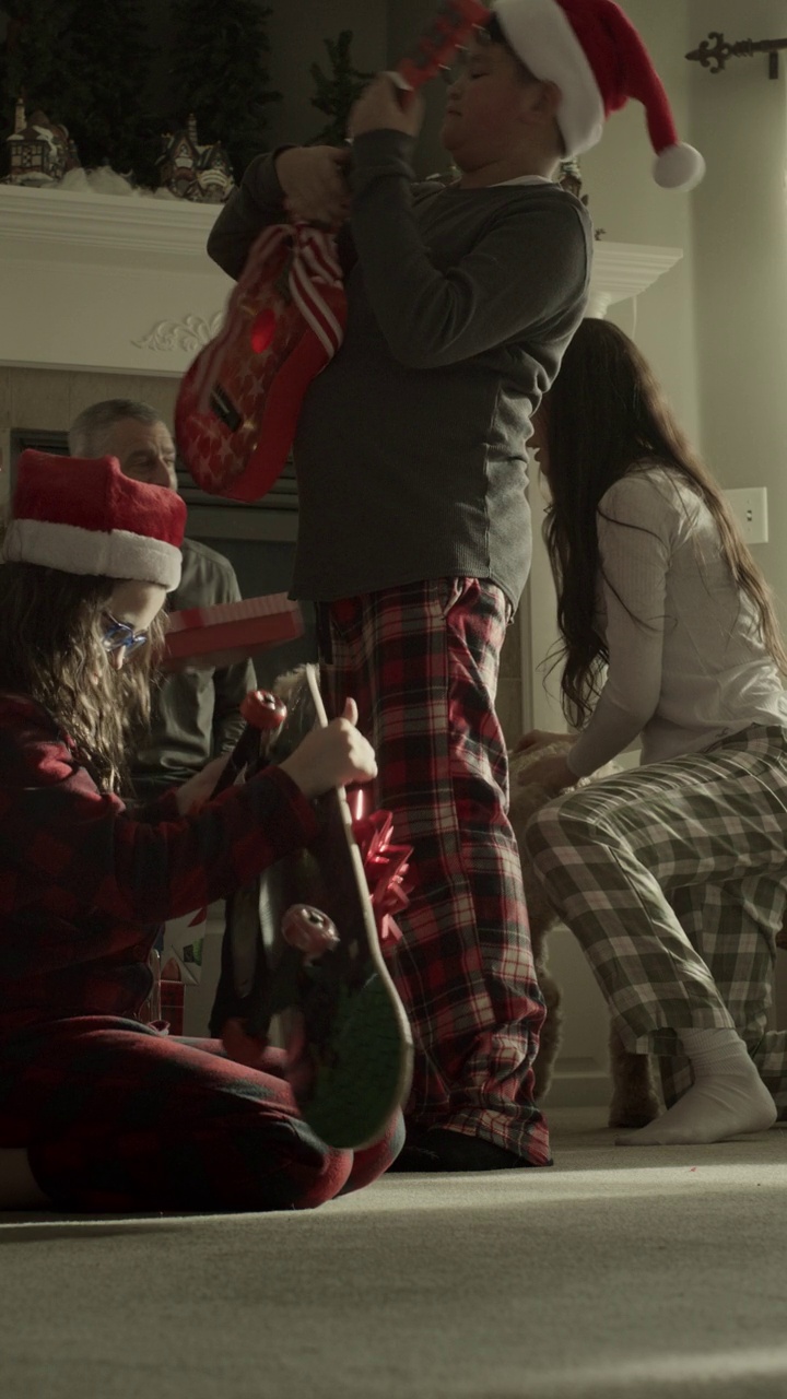 圣诞节早晨，一家人冲向礼物的慢动作——垂直视频/美国犹他州奥勒姆视频下载
