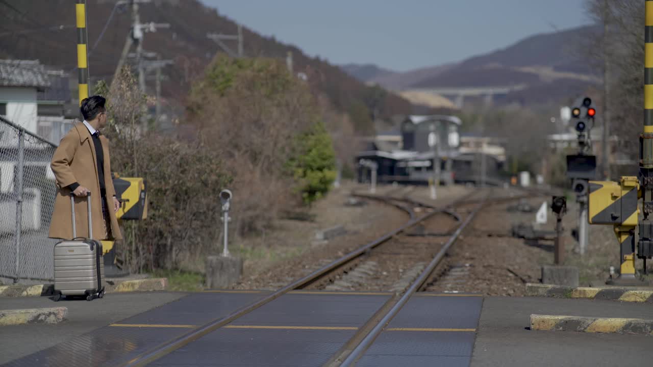 亚洲华人成熟男子走过铁路路口视频下载