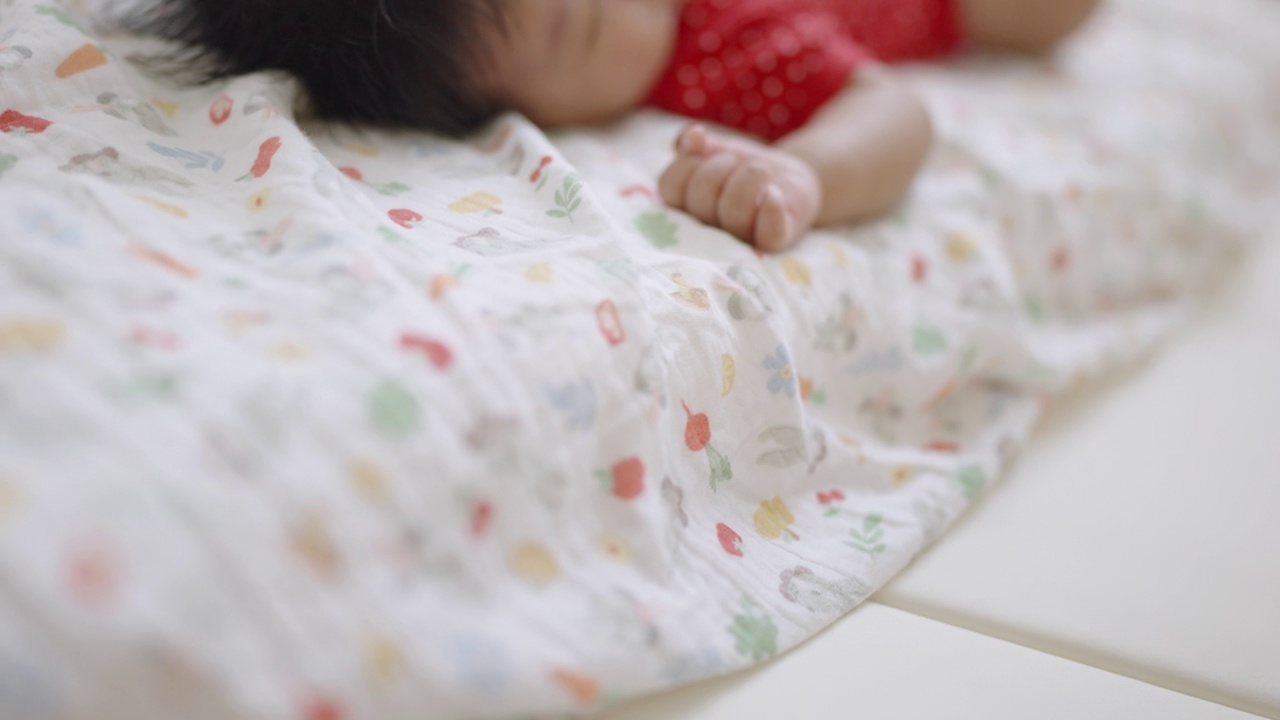 一个月大的男婴在父母卧室舒适的床上睡觉的特写。视频下载