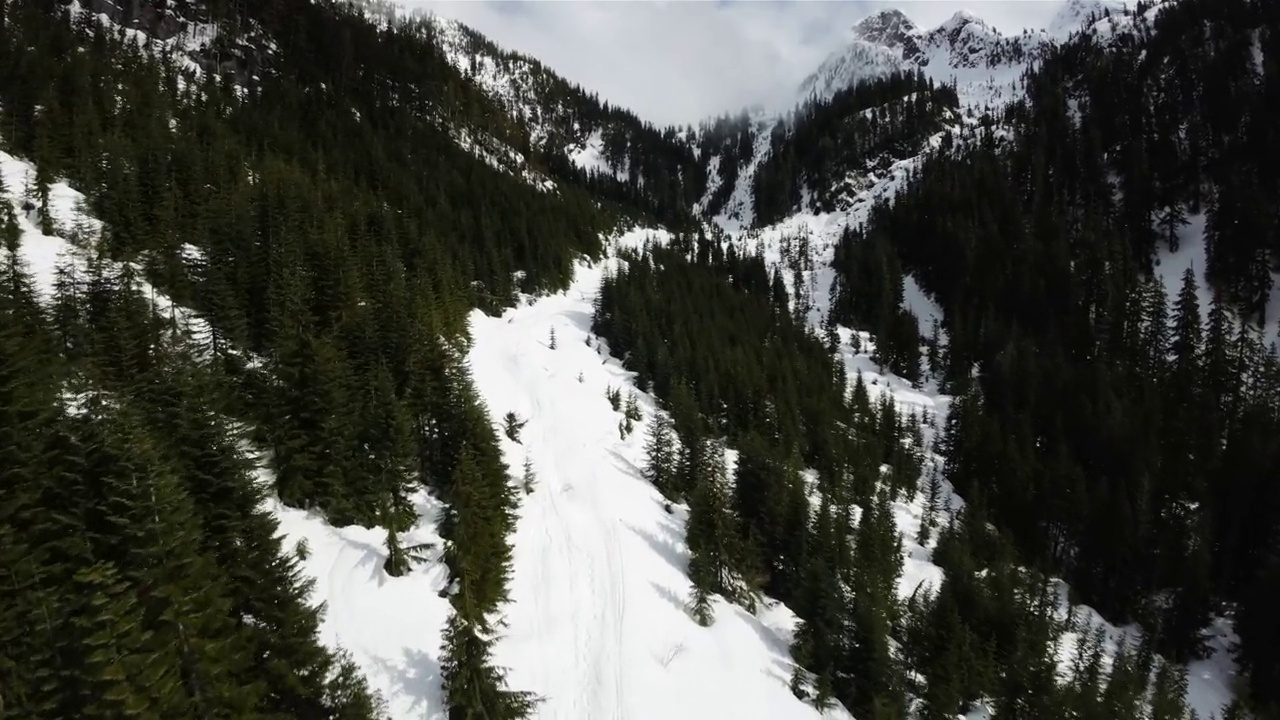 从空中飞过冰雪覆盖的加拿大山地景观。视频下载