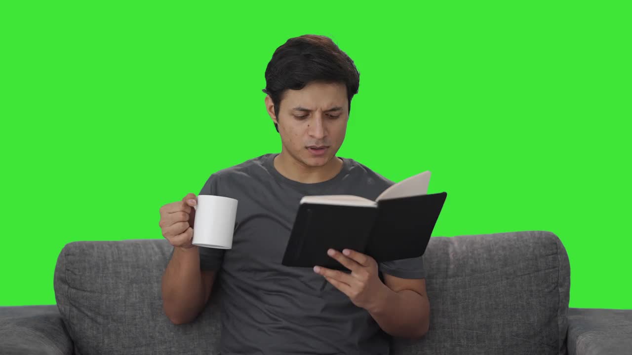 疲惫的印度人一边看书一边喝咖啡绿屏视频下载