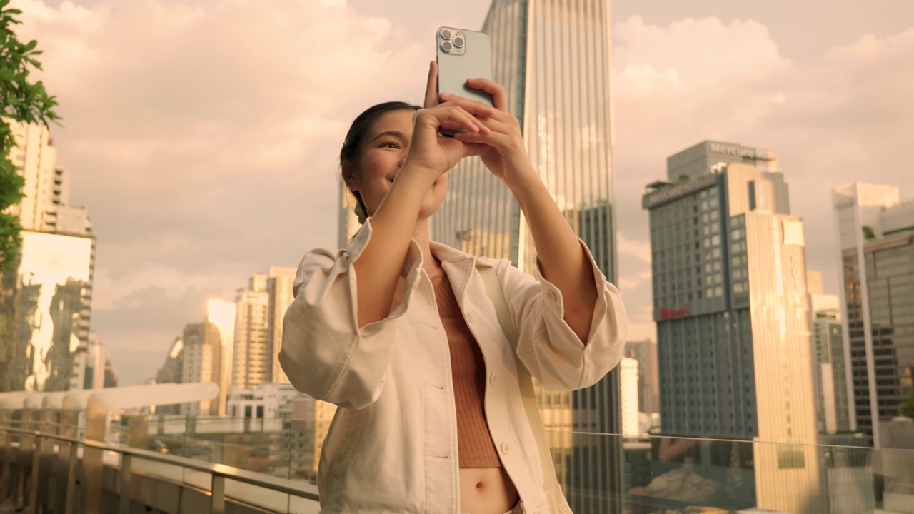 亚洲女性游览泰国曼谷市中心欣赏日落时的摩天大楼视频下载