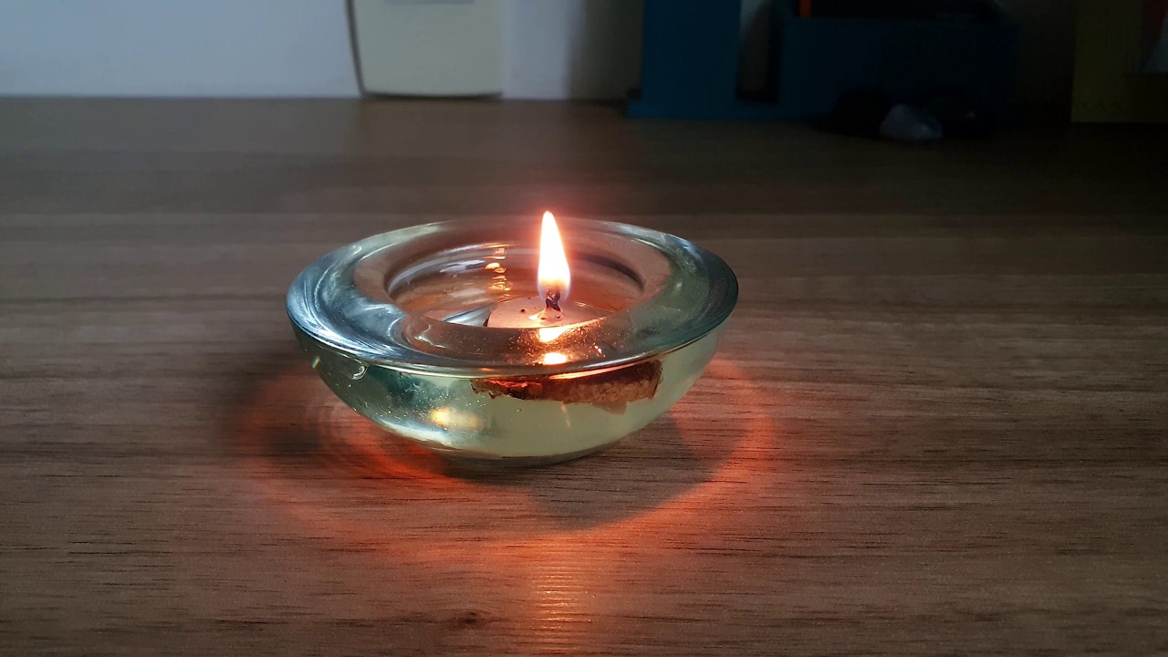 一个小蜡烛在油中燃烧的特写，被聚焦。视频下载