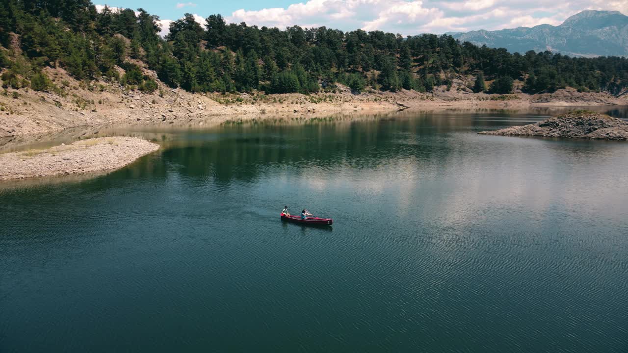 鸟瞰图，妇女和孩子在湖上与养鱼场划独木舟视频下载