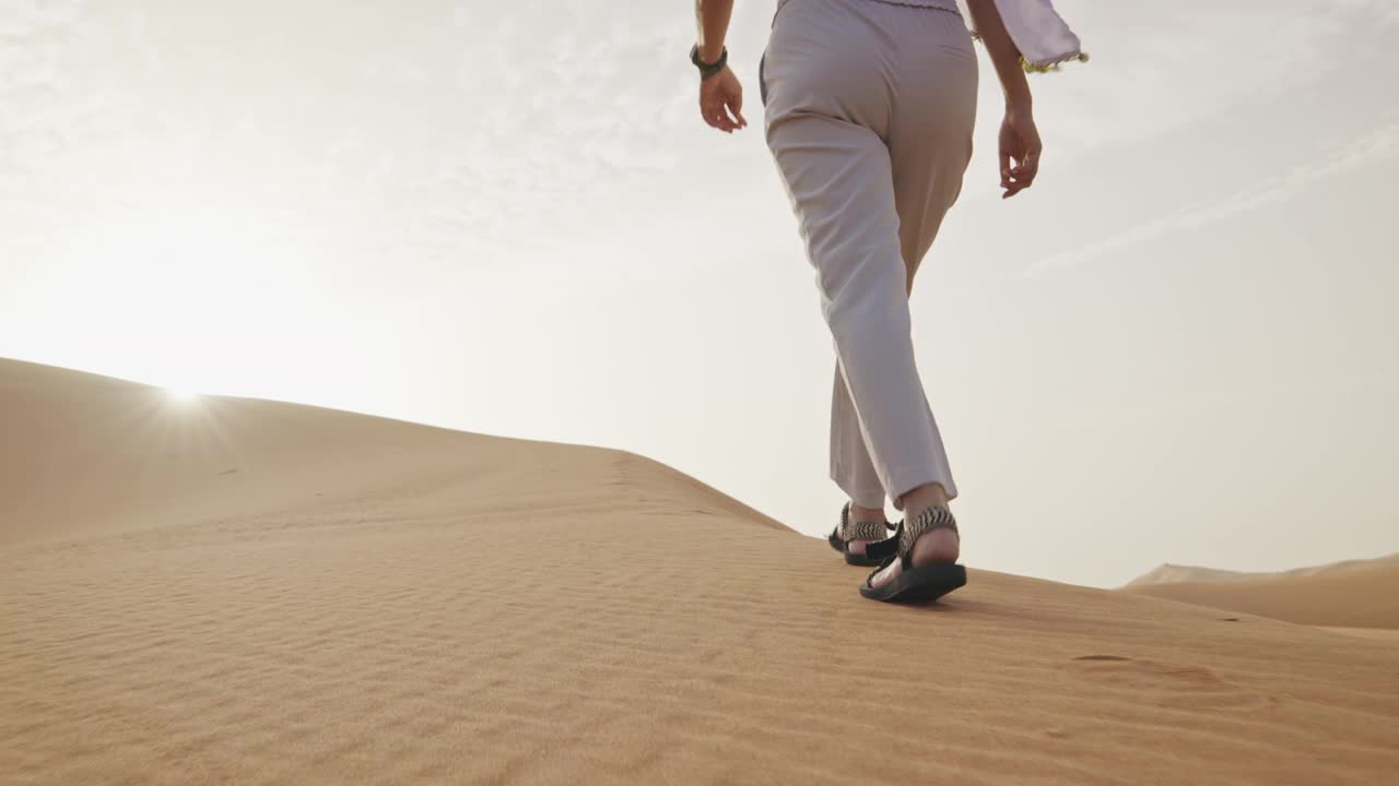 在撒哈拉沙漠的沙丘上行走的女性腿的特写。非洲。缓慢的运动。视频下载