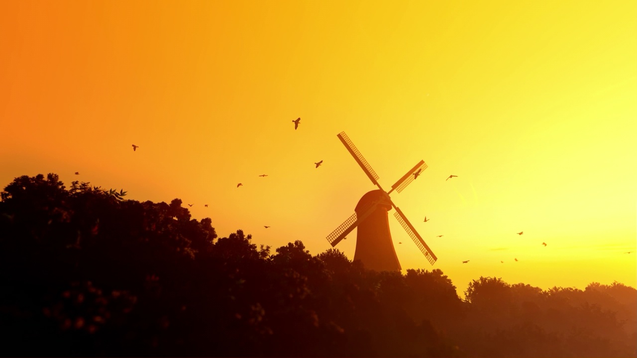 荷兰风车与鸽子在夕阳的黄色天空中飞翔，倾斜视频下载