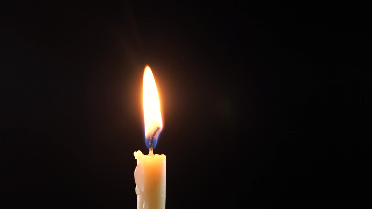黑色背景上蜡烛的特写。蜡烛熄灭。视频下载
