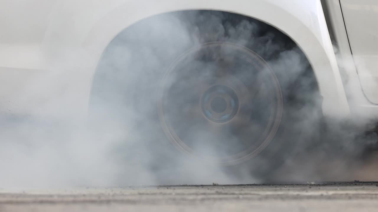 拉力车燃烧轮胎，赛前热身轮胎，拉力车车轮，旋转车轮和烟雾，拉力车燃烧橡胶轮胎准备比赛。视频下载