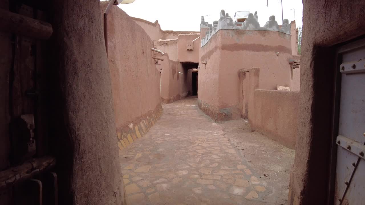 在沙特阿拉伯的Ushaiqer遗产村，摄影机穿过泥砖覆盖的街道。加速视频。视频下载
