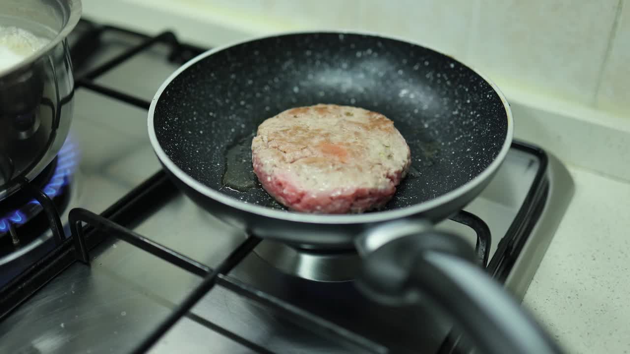 在家庭厨房的炉子上用平底锅煮汉堡视频下载