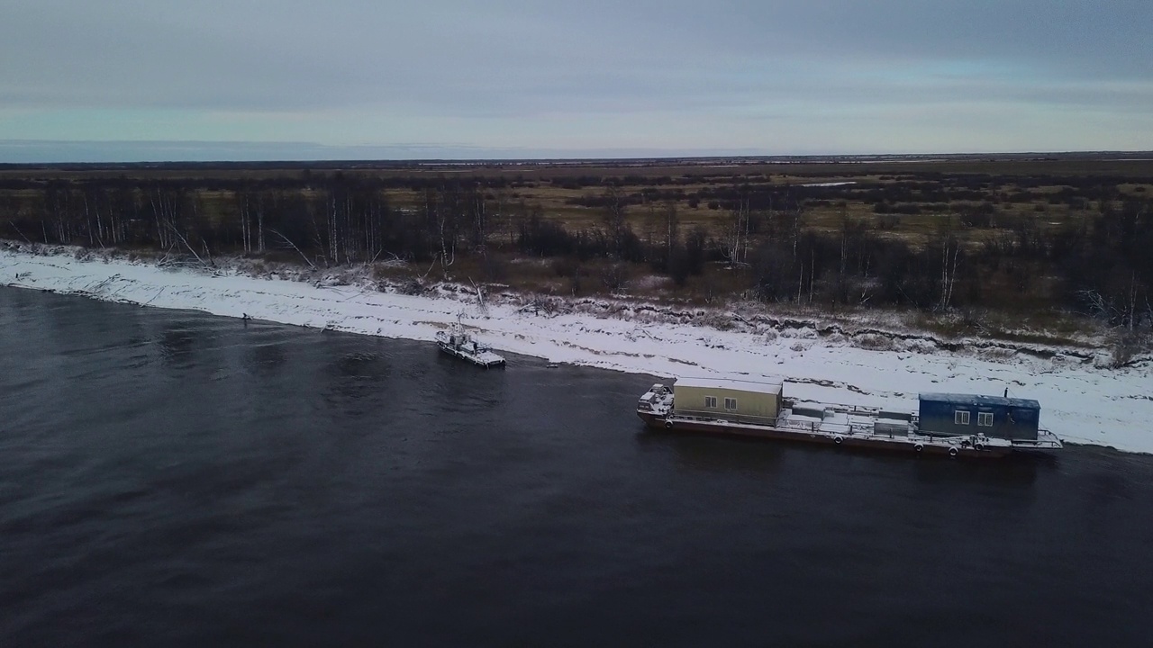 冬季结冰的河流上的驳船鸟瞰图。夹。货物水运的概念。视频下载