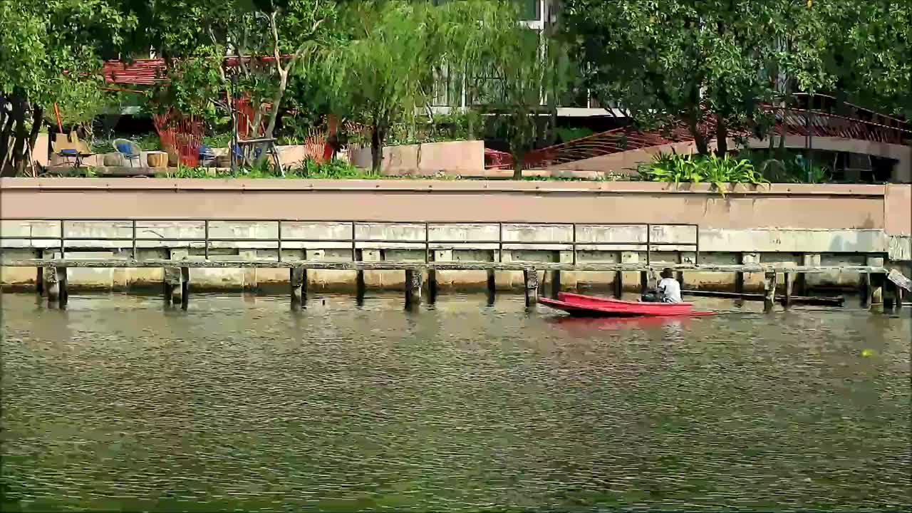 一名男子在泰国曼谷城市运河上划着小船视频下载