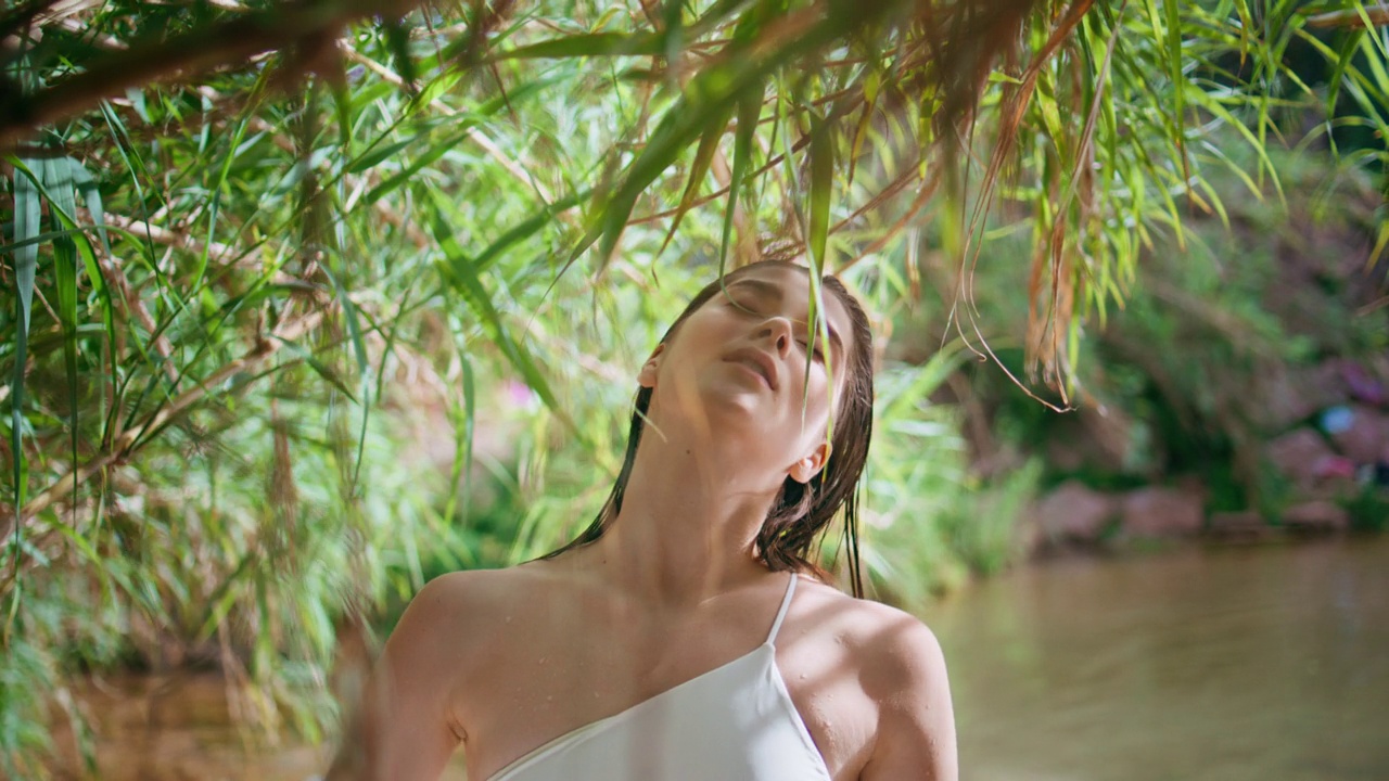宁静的女孩享受大自然呼吸新鲜空气在绿色雨林湖特写视频下载