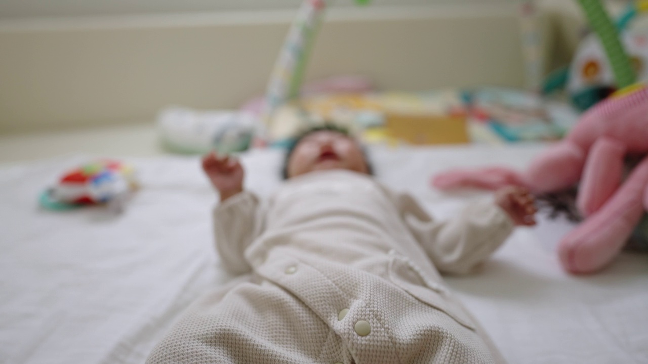 饥饿的女婴躺在她的床上，扭动着，大声哭泣。视频下载