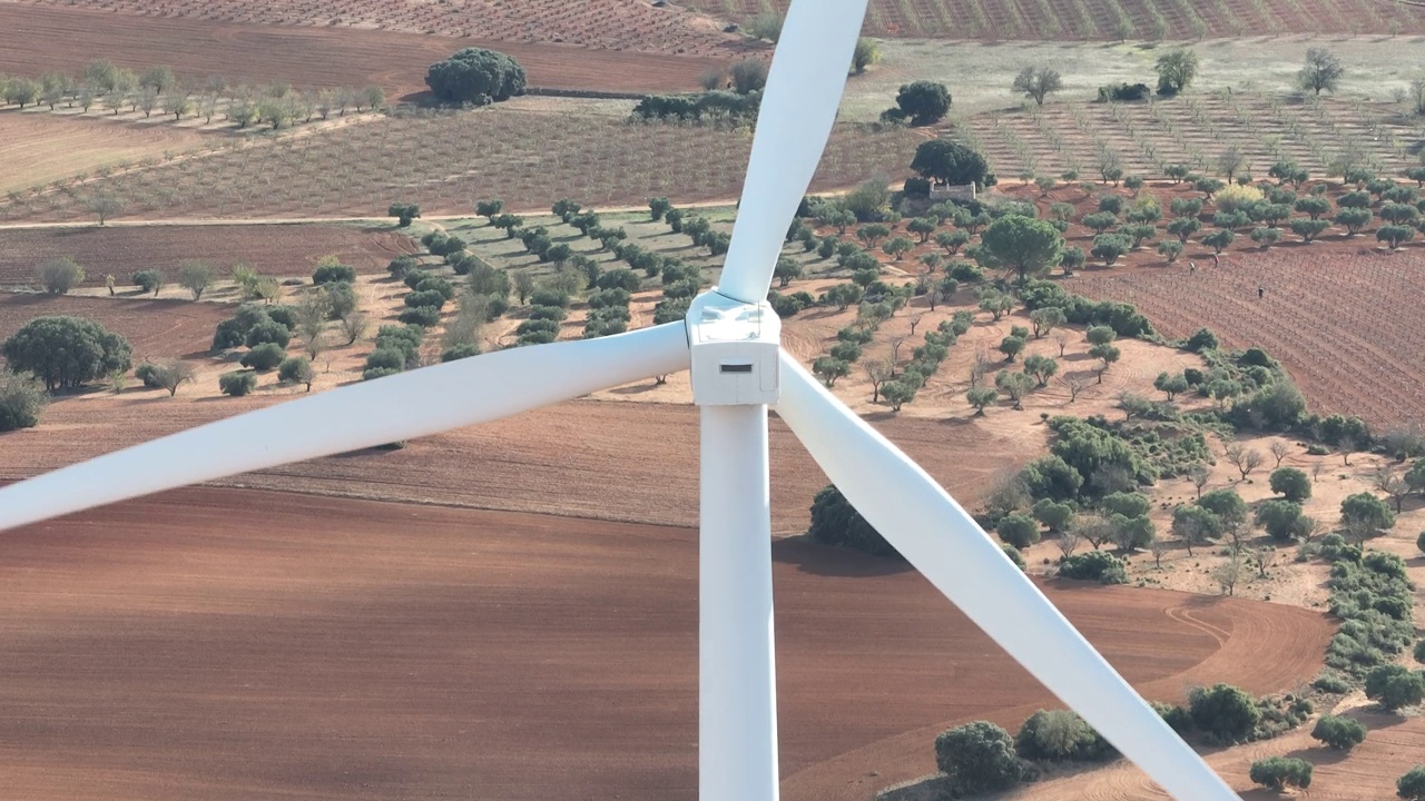 一个风力涡轮机中心的特写，背景是橄榄树视频下载