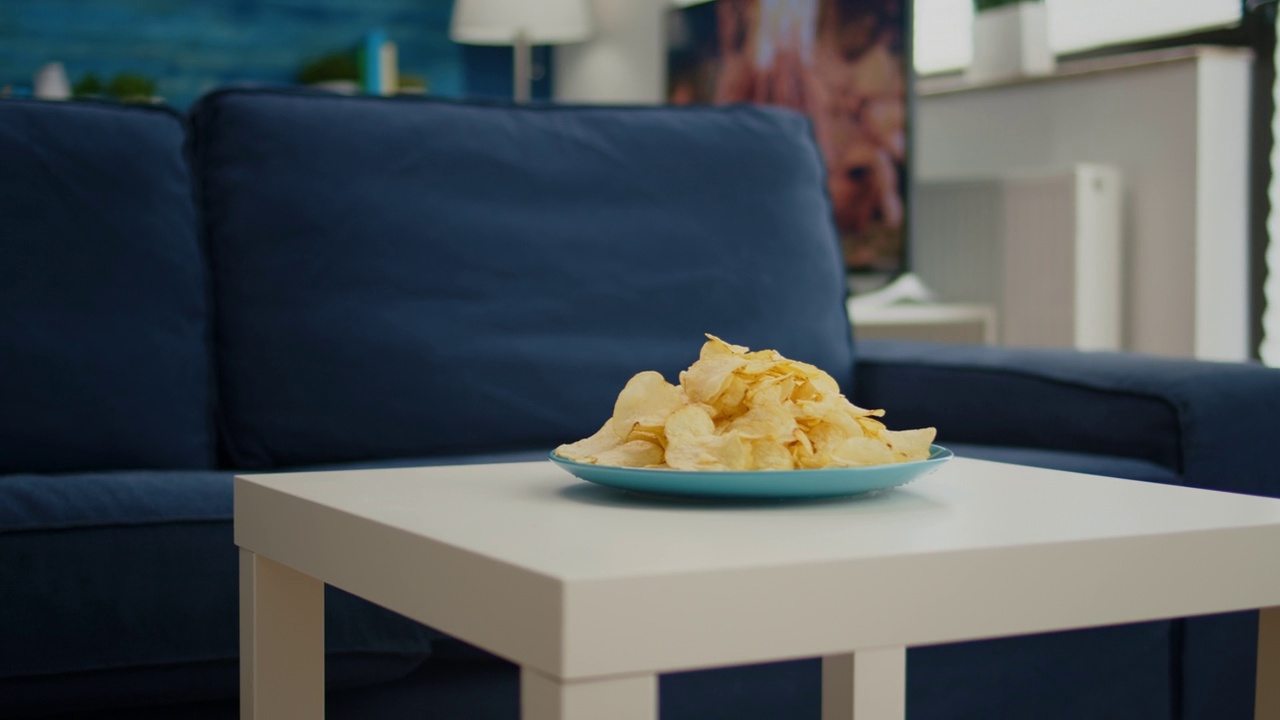薯片、零食坐在舒适的沙发前的咖啡桌上视频下载