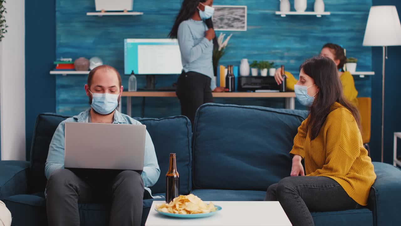 一群戴着口罩的朋友用笔记本电脑计划项目视频下载