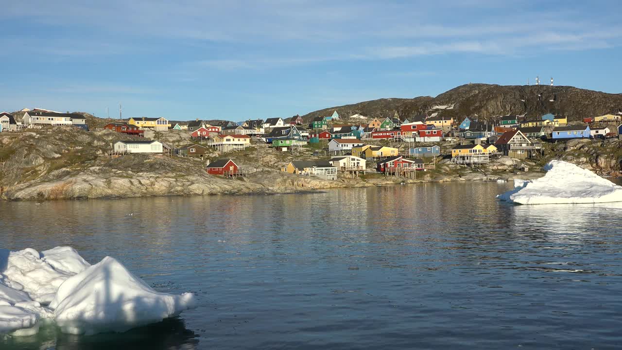 海洋、冰山和格陵兰定居点。格陵兰岛北极村庄伊卢利萨特。色彩斑斓的因纽特人房屋。格陵兰岛极地景观。去北极圈旅行。气候变化，全球变暖。视频下载