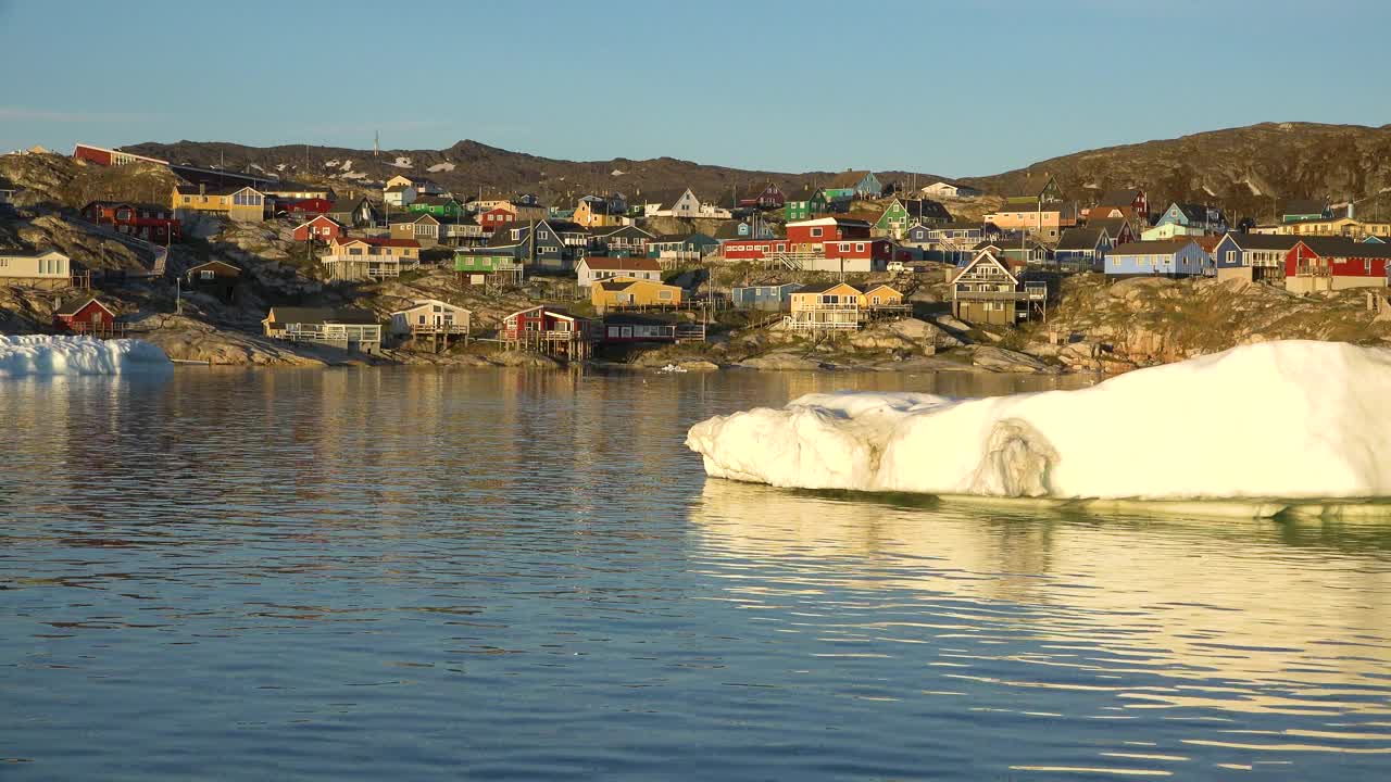 海洋、冰山和格陵兰定居点。格陵兰岛北极村庄伊卢利萨特。色彩斑斓的因纽特人房屋。格陵兰岛极地景观。去北极圈旅行。气候变化，全球变暖。视频下载