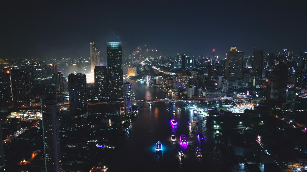 多色烟花在城市和摩天大楼上表演，庆祝夜晚的灯光、河流和曼谷大桥视频下载