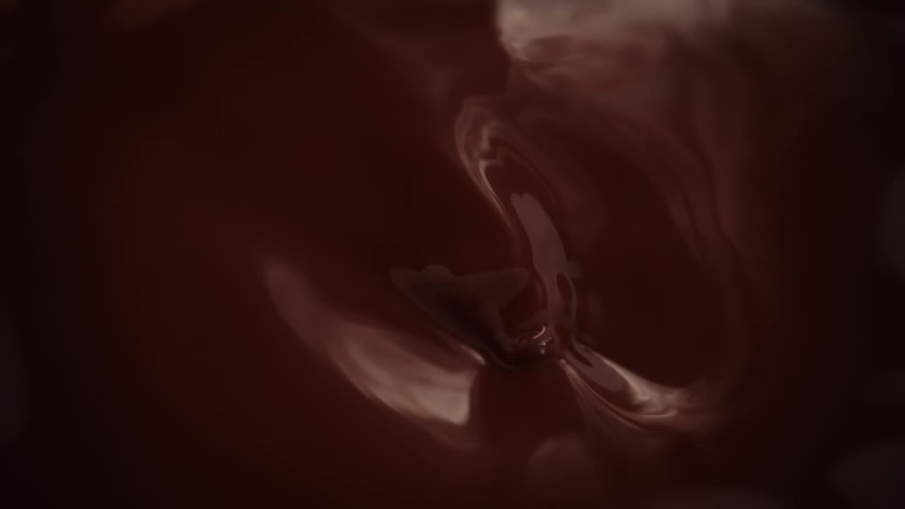 树莓盘旋着落在融化的黑巧克力上视频素材