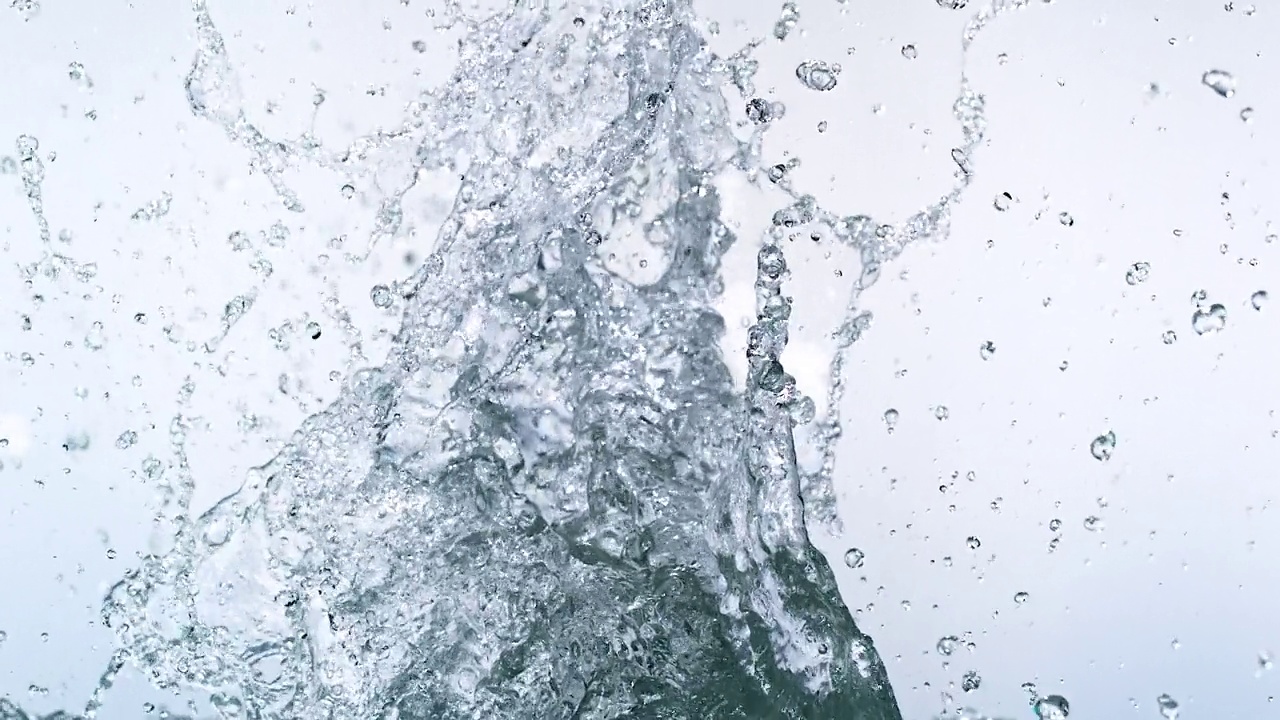 特写镜头和慢动作镜头捕捉到水晶般清澈的水在白色背景下有力地向上溅向液体表面视频下载