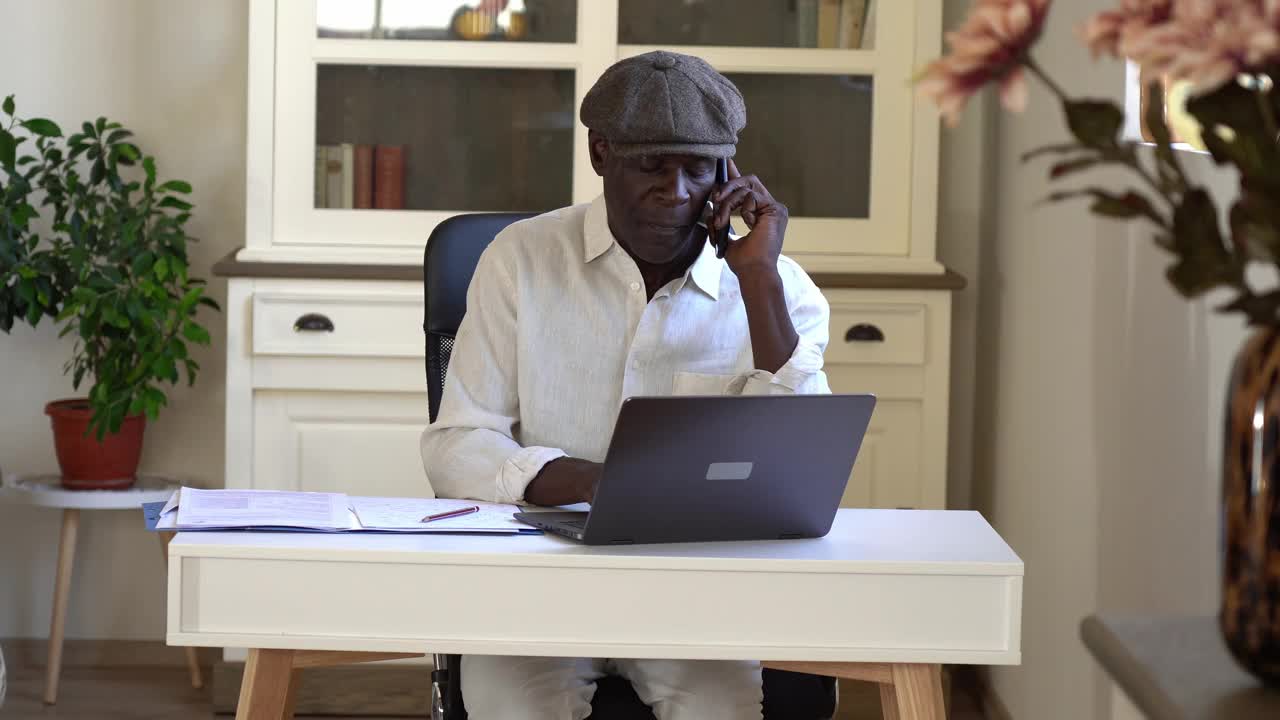 一位非洲资深商人，正在检查公司的预算。他的家庭办公室视频素材