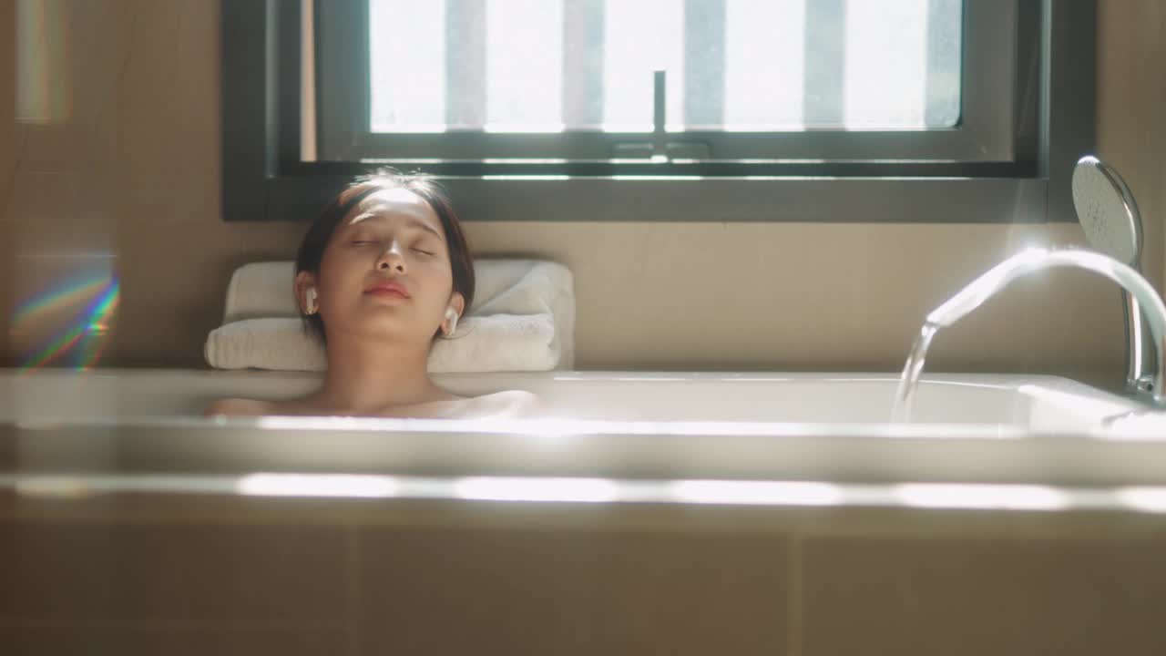 一个亚洲女人一边听音乐一边放松地洗澡视频下载