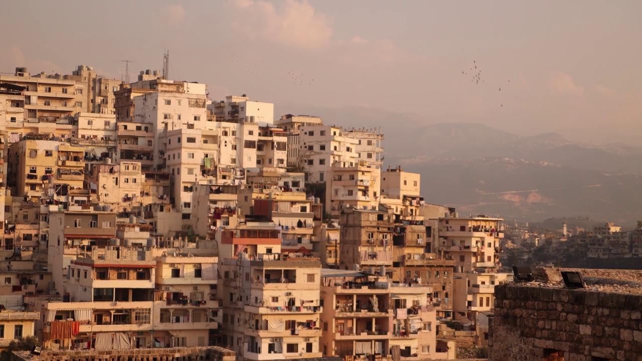 在黎巴嫩北部的黎波里，这是一幅中东房屋在山上的全景镜头，远处是群山视频素材