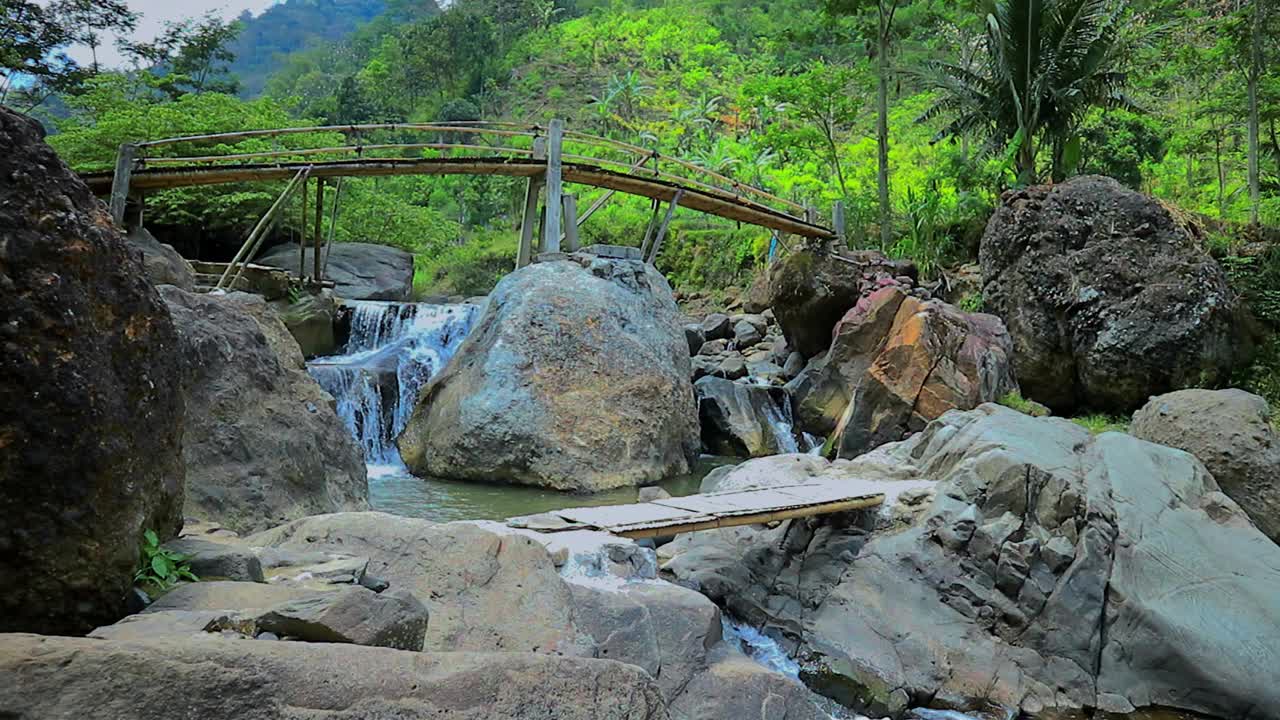 清澈的河流和一座以山为背景的竹桥视频下载