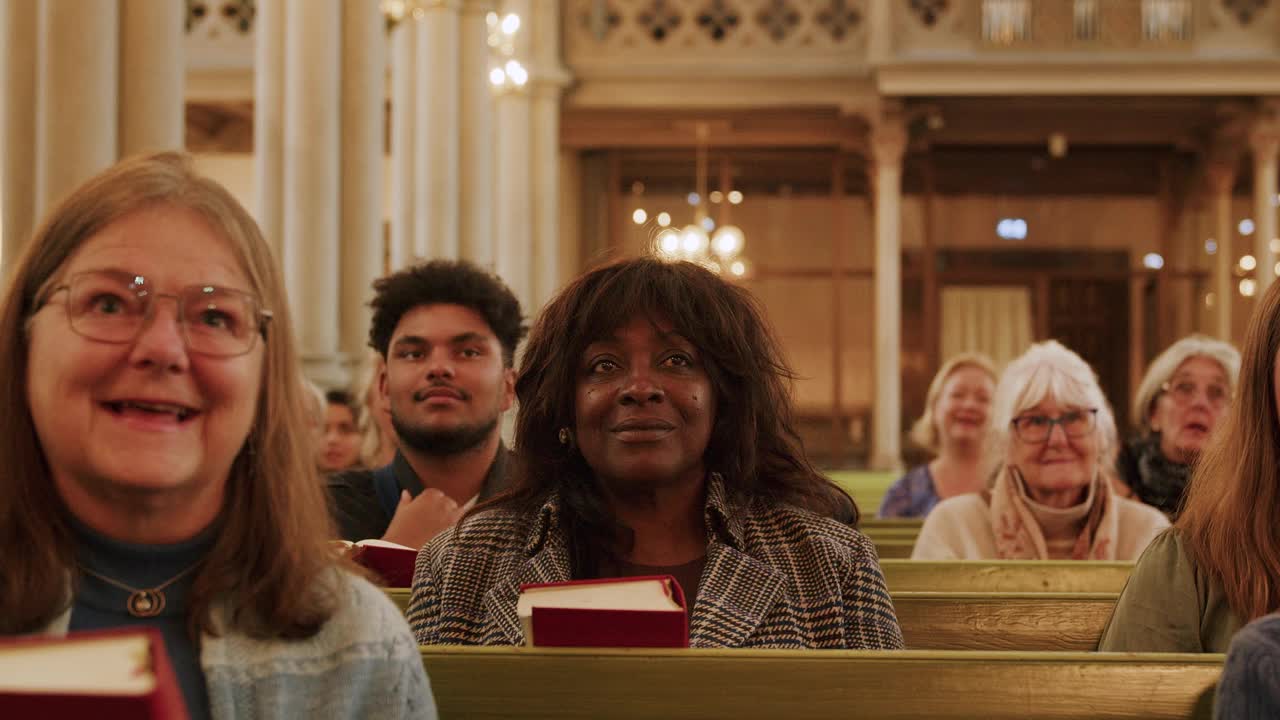 在教堂做弥撒时快乐的男女新教徒的慢动作镜头视频下载