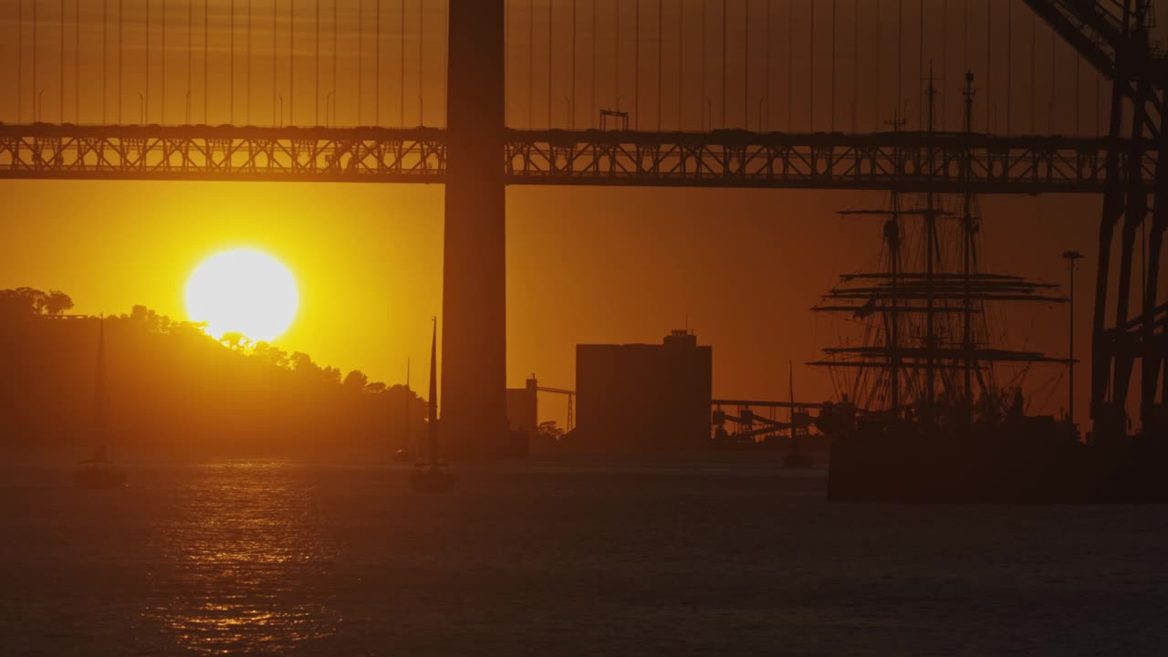 水后的夕阳，帆船前的桥视频下载