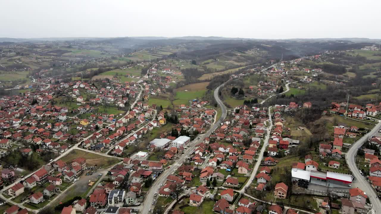 一架无人机在Valjevo镇上空飞行，飞向郊区的农田视频下载