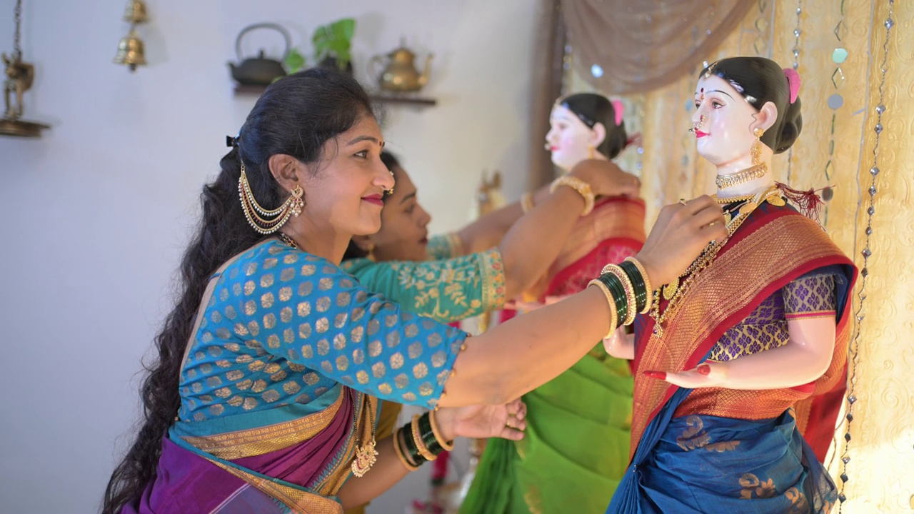 在Ganapati节期间，家中的中年妇女优雅地用装饰品装饰Gauri神像视频素材